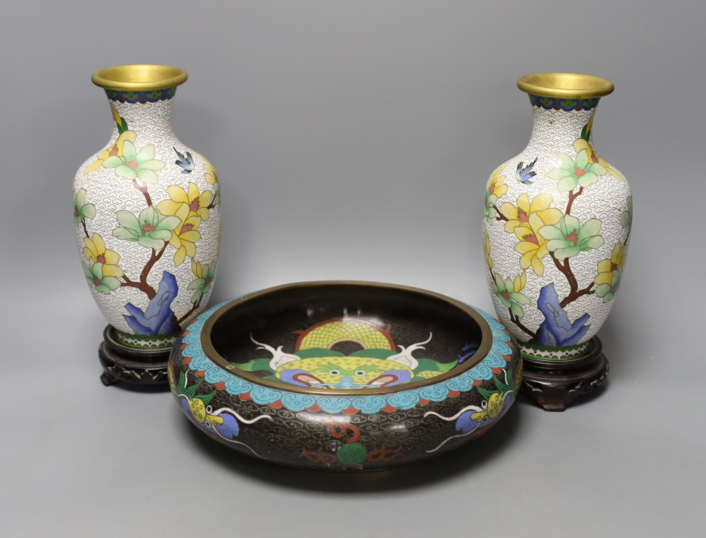 A pair of Chinese cloisonné enamel vases, 25cm tall including stands, together with a Chinese cloisonné enamel dragon bowl (3)